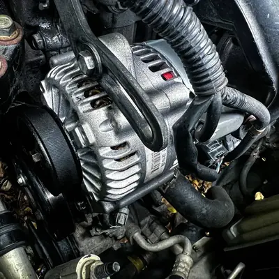 Close-up of an alternator and belt in an engine bay