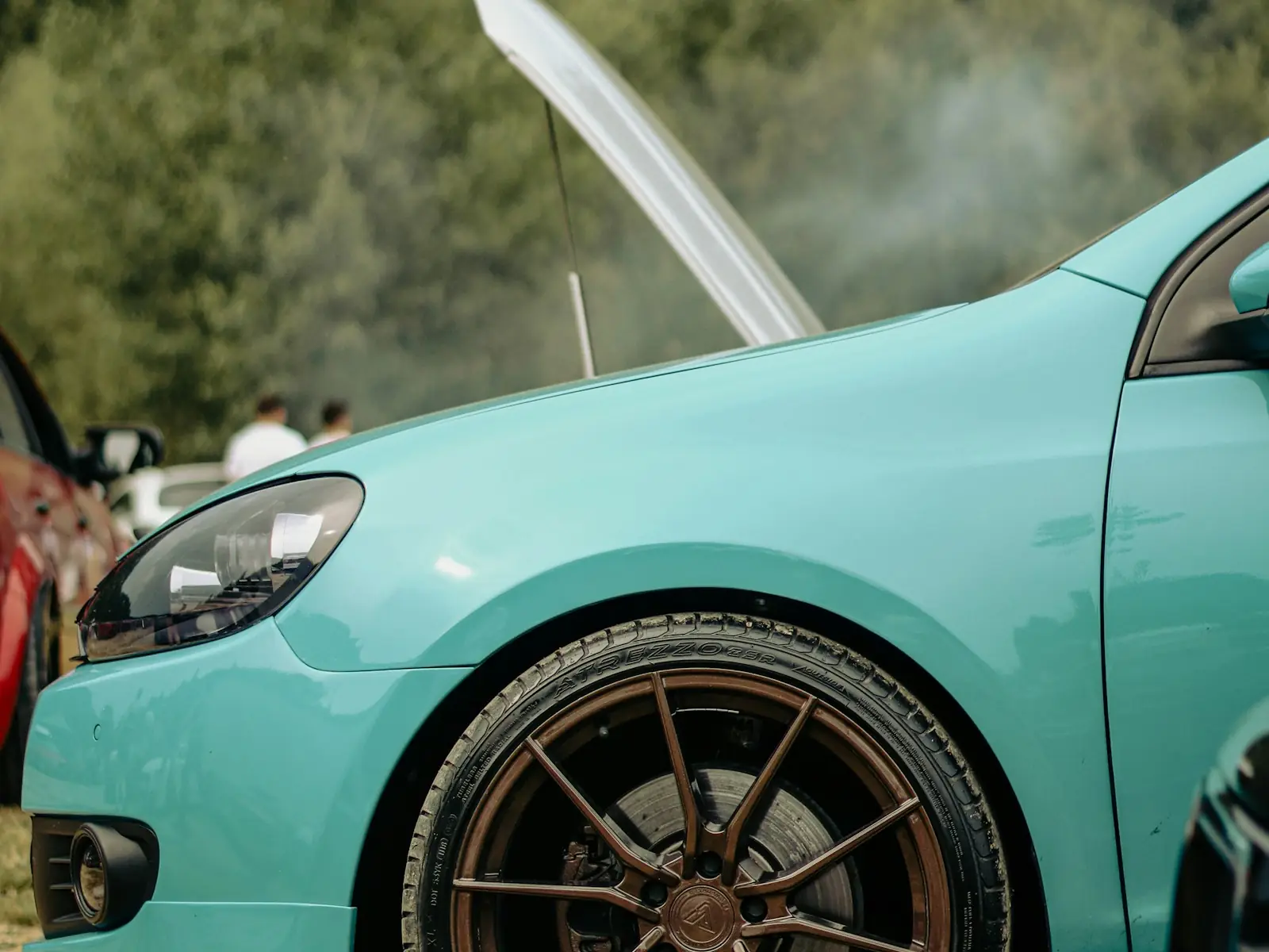 Steam rising from under the open hood of a car
