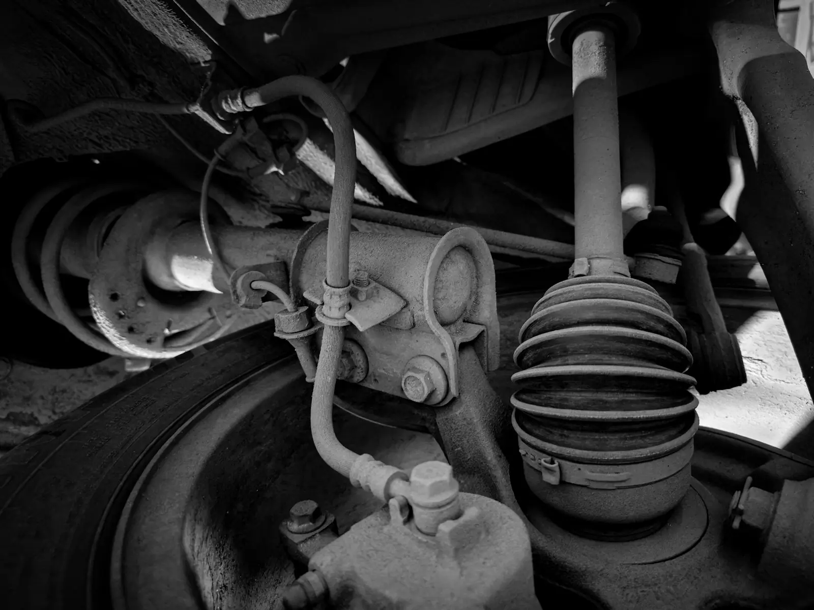 Suspension parts under a car: the strut, axle boot and brake line