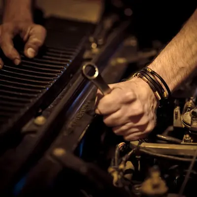 Hands with a wrench working on an engine